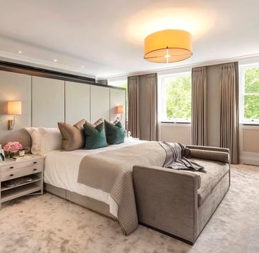 Cozy bedroom with a bed, bedside table, chaise lounge, featuring neutral tones, dark green accentst