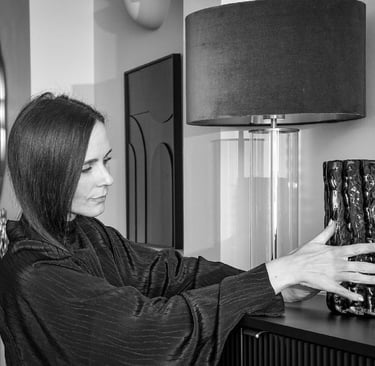 Amy Parker Williams decorating a shelf. Placing an ornament next to a lamp