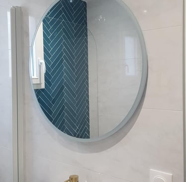 Miroir rond au dessus un meuble avec vasque poser et robinetterie couleur or