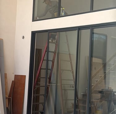 a man standing on a ladder to reach a ladder windows door cleaning post construction job