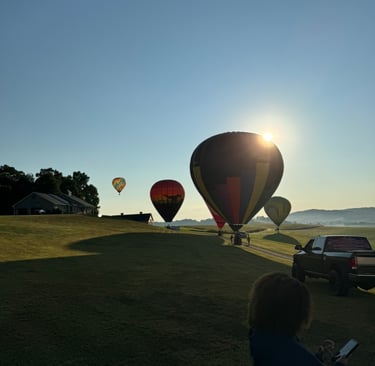 hot air balloons landing in a field after a ride