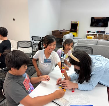 A group of kids in a team building the tallest tower out of a set of legos.
