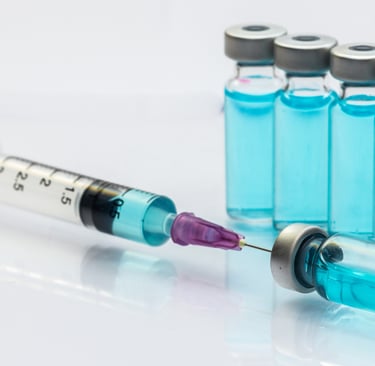 Seringa com agulha e frascos de liquido azul