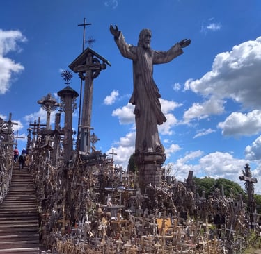 A wooden statue of Jesus stands amidst thousands of wooden crosses at the Hill of Crosses in Lithuania.