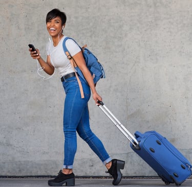 a woman walking down the street with a suitcase