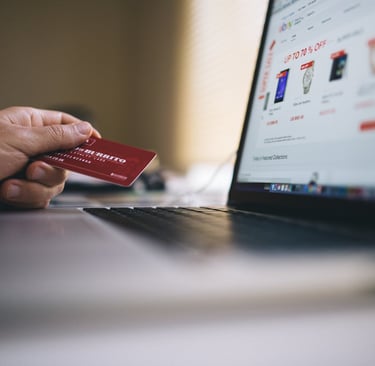 A hand holding a credit card about to make a purchase
