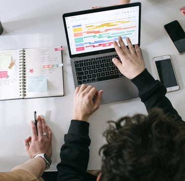 A product team analysing a project timeline displayed on a laptop 