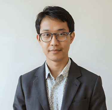 A portrait of a man with glasses wearing a suit