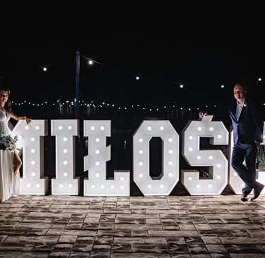 a bride and groom pose for a photo in front of the word's '