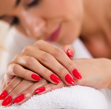 cliente emozionata della sua nuova manicure colore rosso con espressione rilassata in accappatoio 