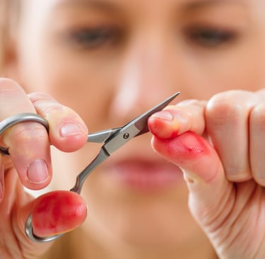 ragazza che cerca con la forbicina di tagliarsi le cuticole 
