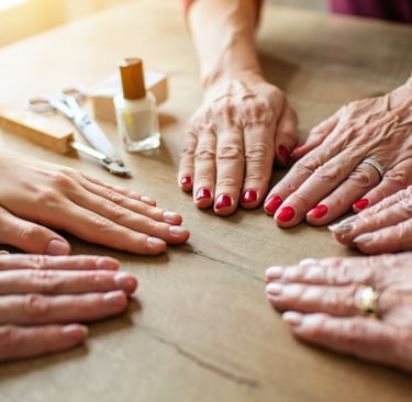 diversi tipi di mani in base all'eta con diversi Tipi di smalto e colori su un tavolo di legno