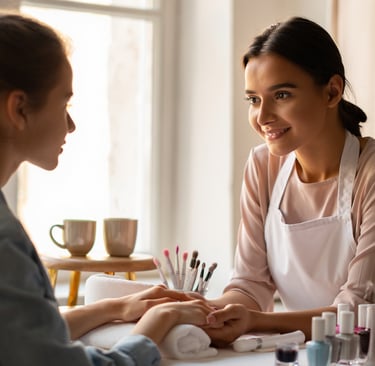 onicotecnica e cliente in postazione mentre chiacchierano con 2 tazze di caffè 