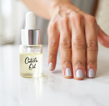 mano con unghie glitterate con applicato l'olio per cuticole raffigurato di fianco nella boccetta 