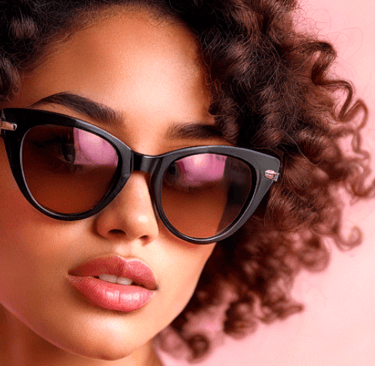 a woman dark curly with a black cat eye  sunglasses