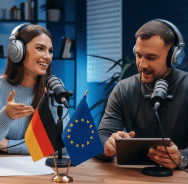 a man and woman sitting at a table with a tablet