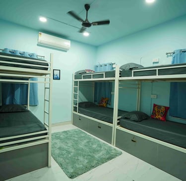 a blue room with bunk beds and a fan