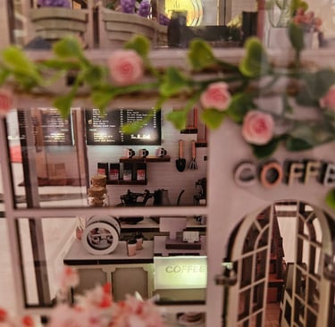 Coffee Garden book nook, miniature café details, plants, and warm interior lighting.