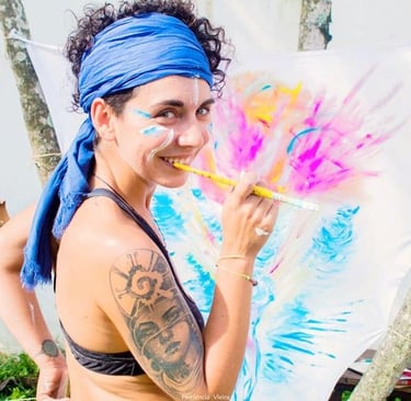 Naía souriante avec un pinceau, et une toile en cours de live painting