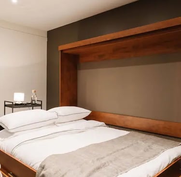 Une chambre avec un lit, une lampe et un cadre artistique