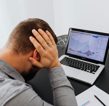 Empresário preocupado analisando relatórios financeiros, representando os custos invisíveis que redu
