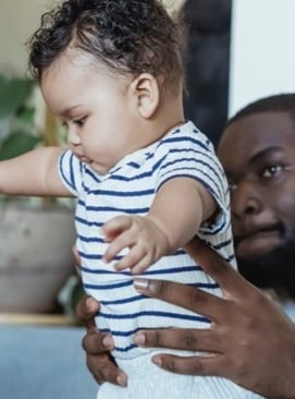 vader helpt met eerste stapjes