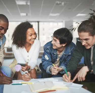 A group of people talking about a group project around a table.