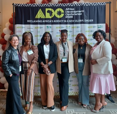 Six female leaders in front of the 2026 Africa Development Conference at Harvard banner smiling.
