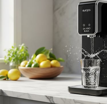 Purificador de água Da Vinci preto enchendo copo em cozinha moderna com limões ao fundo