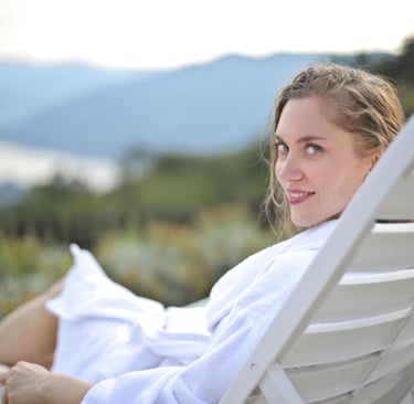 Woman relaxing on resort lounger with scenic mountain view — spa deals