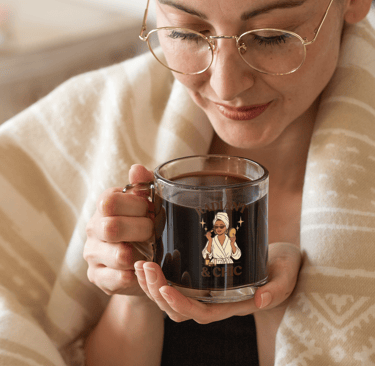 “Woman wrapped in a cozy blanket holding a clear glass mug of coffee with the ‘Radiant & Chic’ desig