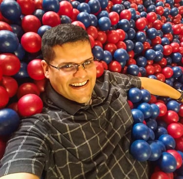 Man with glasses in a ball pit