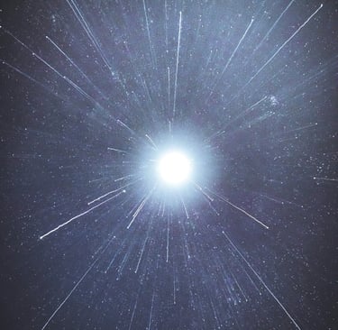 a bright blue sky with stars and a bright light shining through the stars