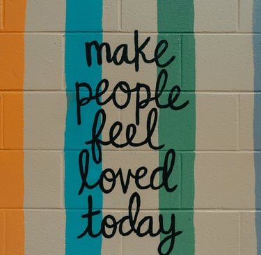 a wall with a quote on it 'make people feel loved'.