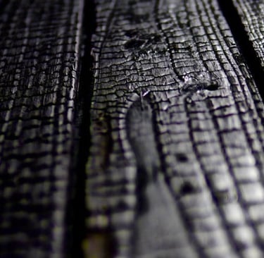 Close-up texture of charred Shou Sugi Ban wood planks with a dark, carbonized burnt finish.