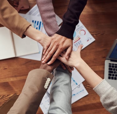 a group of people holding hands together in a circle