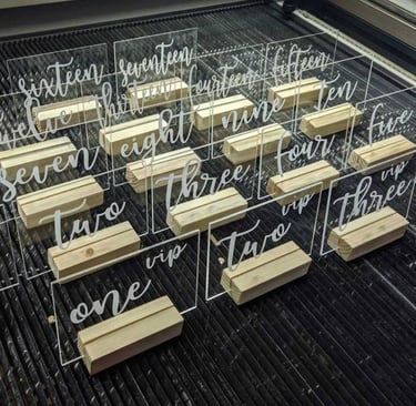 Clear acrylic table numbers with elegant white script numbering from 'one' to 'fifteen,' Rectangular