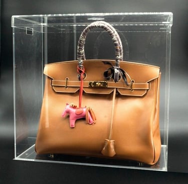 Brown luxury bag in a transparent acrylic case.