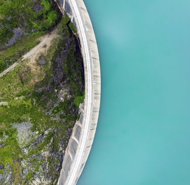 a water dam wall that separates the water from the green area downstream
