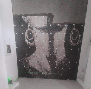 Präzise Anbringung eines Glasmosaiks mit Hilfe eines Lasers für perfekte Ausrichtung.