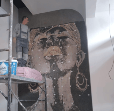 Montage eines maßgeschneiderten Glasmosaiks in einem stilvollen Café-Interieur.