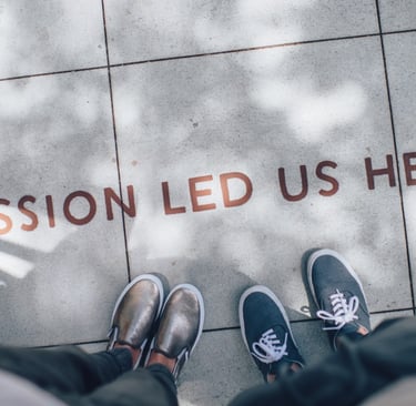 a person standing on a tile floor with a sign that says passion led us here