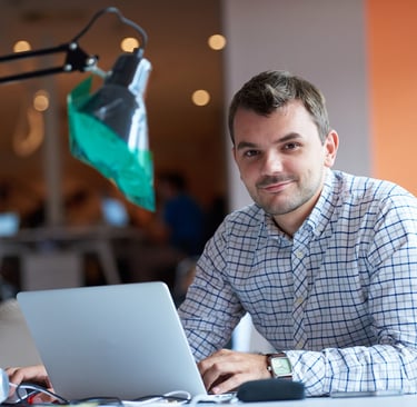 a man sitting at a desk with a laptop computer
