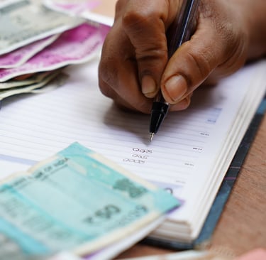 a person holding a pen and writing on a notebook
