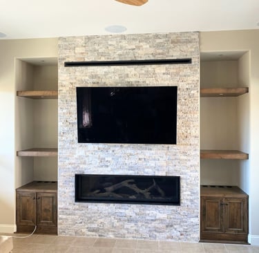 stone work fireplace surround with large mounted TV. Custom shelving on either side. Colorado Springs fireplace updates.