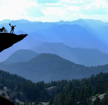 Motorcycle Rider on dangerous cliff feeling triumphant after GJ Silver Ride to Rise Coaching