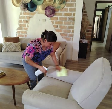 a woman cleaning a couch with a sponge pad