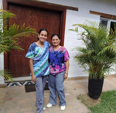two women standing in front of a house