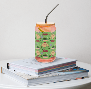 a glass tumbler with a pattern with a sweater blanket and stack of books