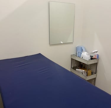 A cozy small room featuring a blue bed and a mirror, creating a serene and inviting atmosphere